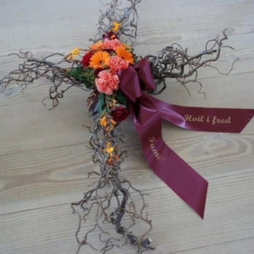Blomsterkors til begravelse med orange blomster og bånd