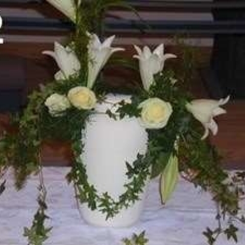 Urnedekoration med hvide liljer og grønne ranker