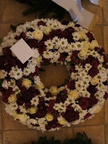 Begravelseskrans med bordeaux roser og hvide blomster