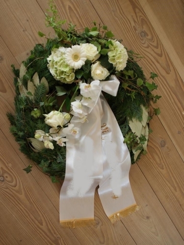 Begravelseskrans med røde roser og gule og hvide blomster