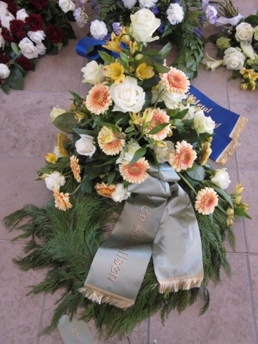 Begravelseskrans med hvide roser samt gule og orange blomster