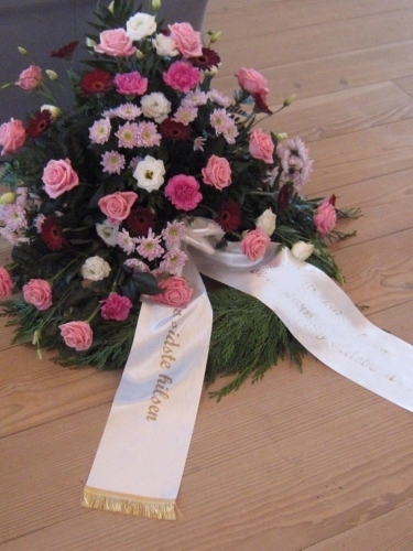 Begravelseskrans med pink og rosa blomster med bånd