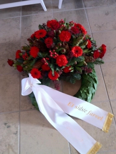 Begravelseskrans med gule roser og blomster med hvidt bånd