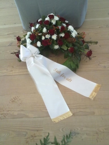 Begravelseskrans med tulipaner og lyse nelliker med bånd