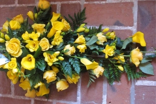 Bårebuket i gule nuancer med roser, calla og grønne bregner