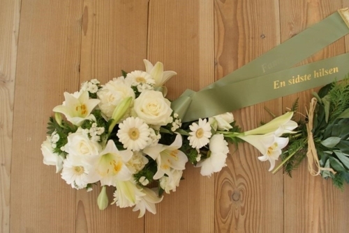 Bårebuket med hvide blomster og grønt bånd med teksten En sidste hilsen
