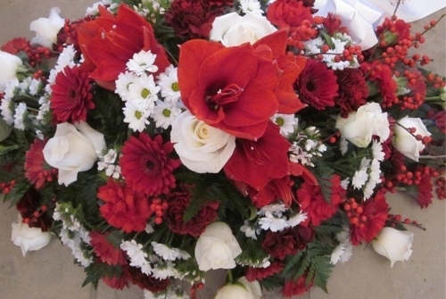 Begravelsesdekoration med rød amaryllis, hvide roser og røde blomster