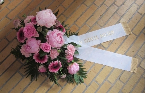 Begravelseskrans i pink nuancer med hvidt bånd med teksten En sidste hilsen