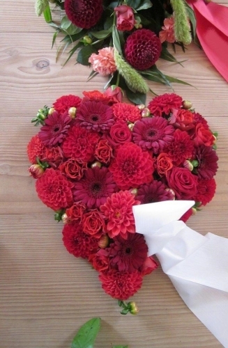 Blomsterhjerte med røde roser og røde blomster