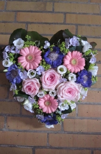 Blomsterhjerte i rosa og lilla nuancer til begravelse