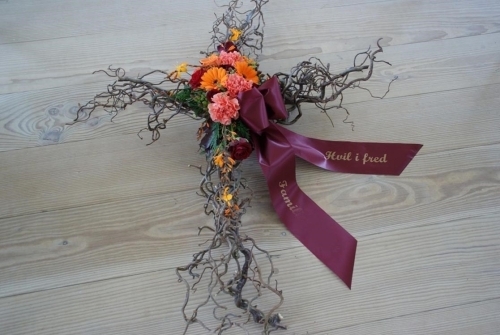 Blomsterkors til begravelse med orange blomster og bånd