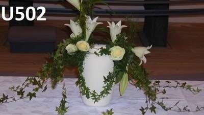 Urnedekoration med hvide liljer og grønne ranker